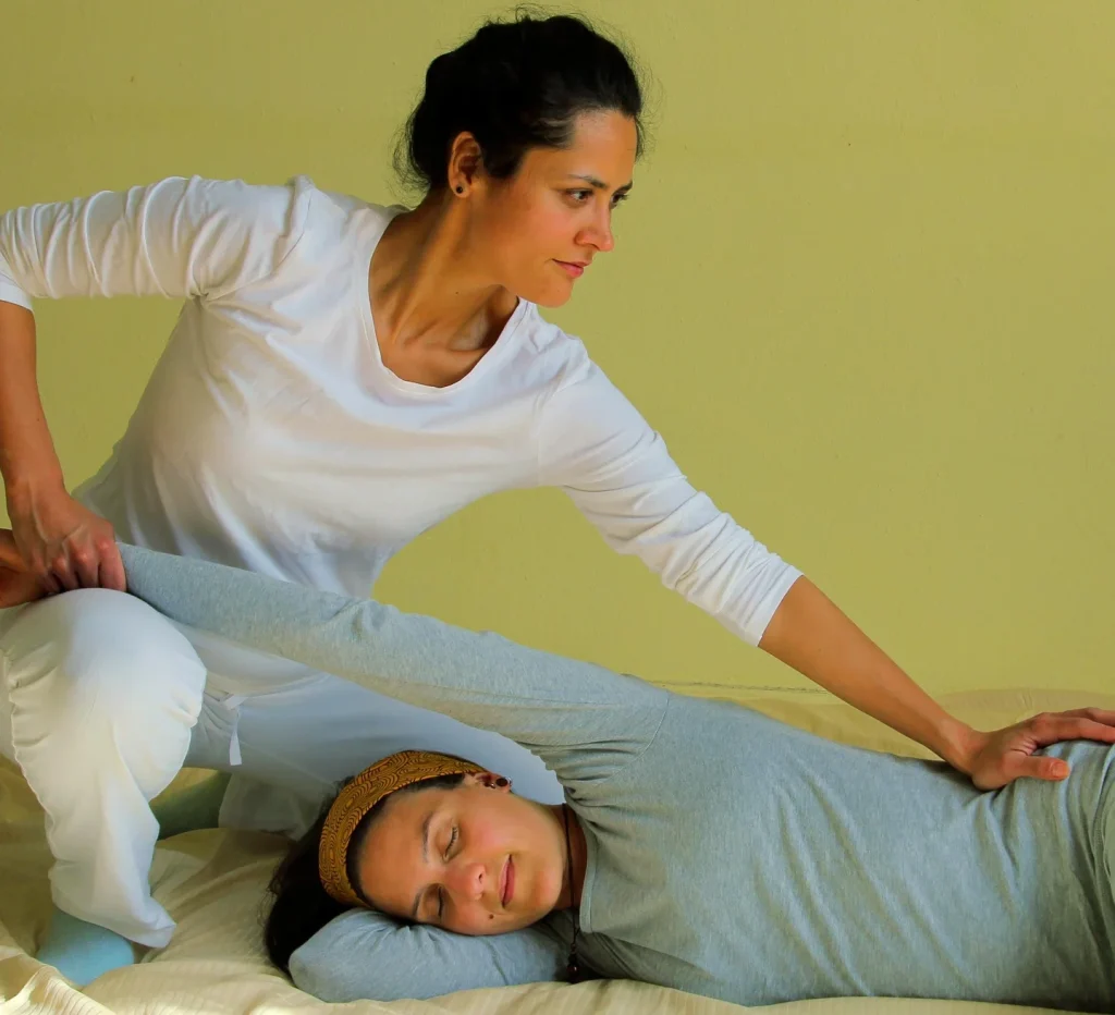 Micheel Muñoz Estay dando masaje Shiatsu a una mujer recostada, sesión de relajación profunda en San Sebastián